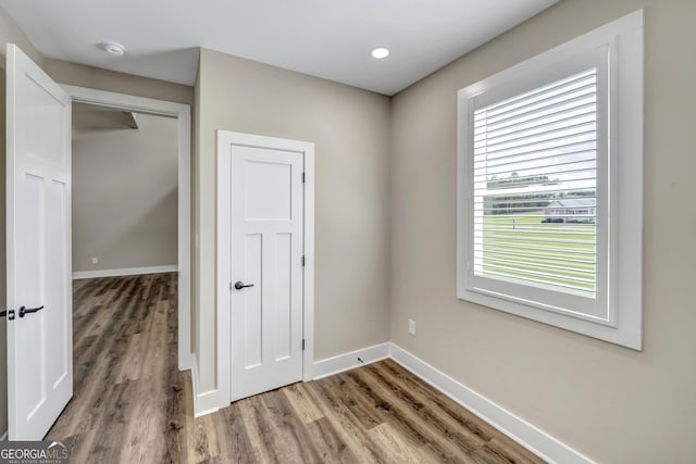 unfurnished bedroom with hardwood / wood-style flooring and a closet