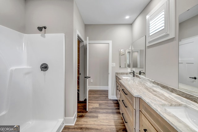 bathroom with vanity, hardwood / wood-style floors, and a shower