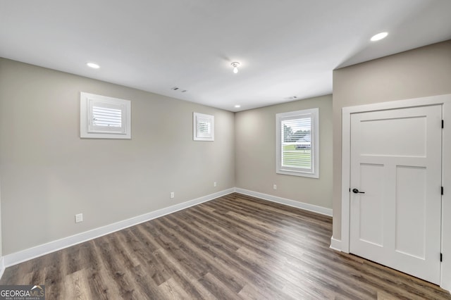 unfurnished room with dark hardwood / wood-style flooring