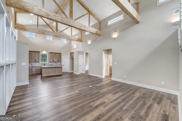 unfurnished living room with vaulted ceiling with beams and dark hardwood / wood-style flooring