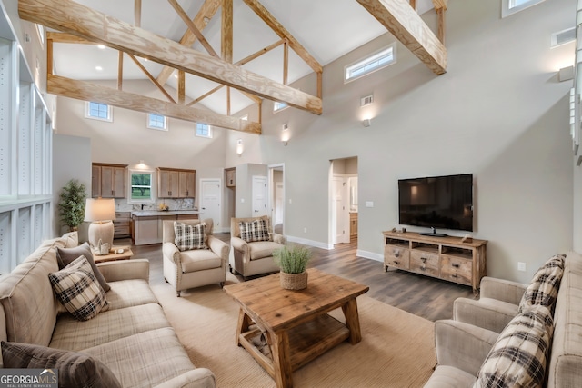 living room with beamed ceiling, wood-type flooring, and sink