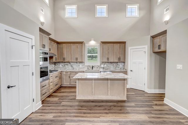 kitchen featuring sink, dark wood-type flooring, light brown cabinets, and a kitchen island