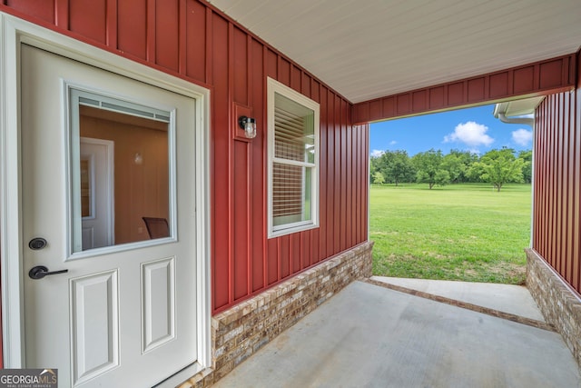 doorway to property with a yard and a patio area