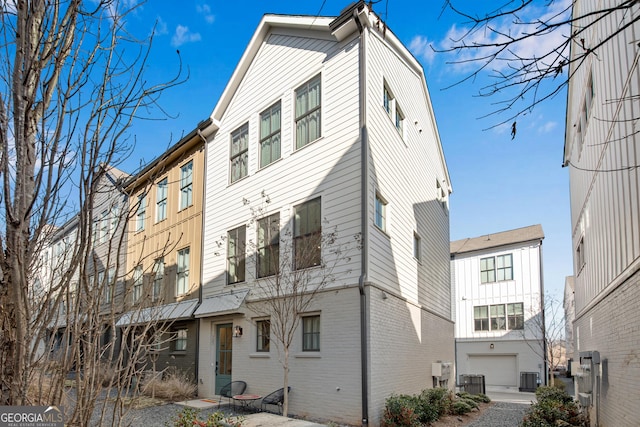 back of property featuring central AC and a garage