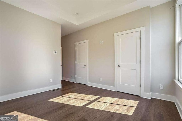 unfurnished bedroom with dark hardwood / wood-style flooring