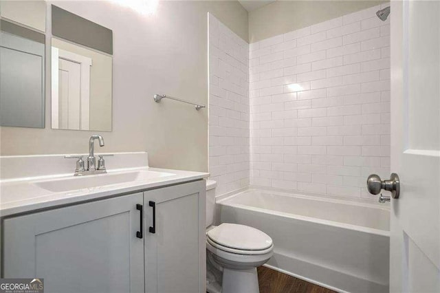 full bathroom featuring vanity, wood-type flooring, washtub / shower combination, and toilet