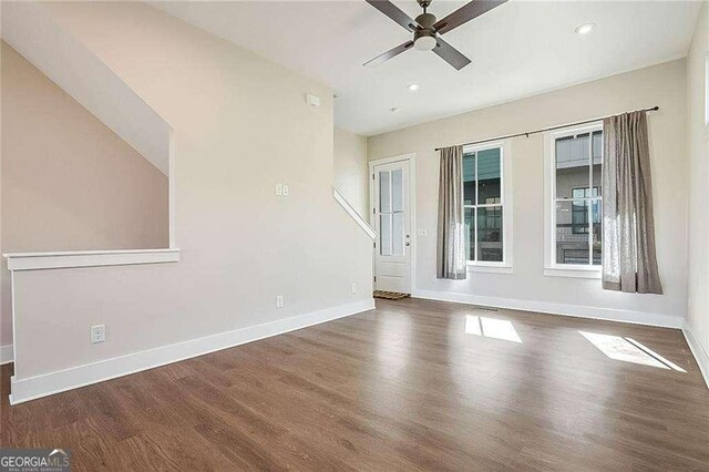 spare room with plenty of natural light, dark wood-type flooring, and ceiling fan