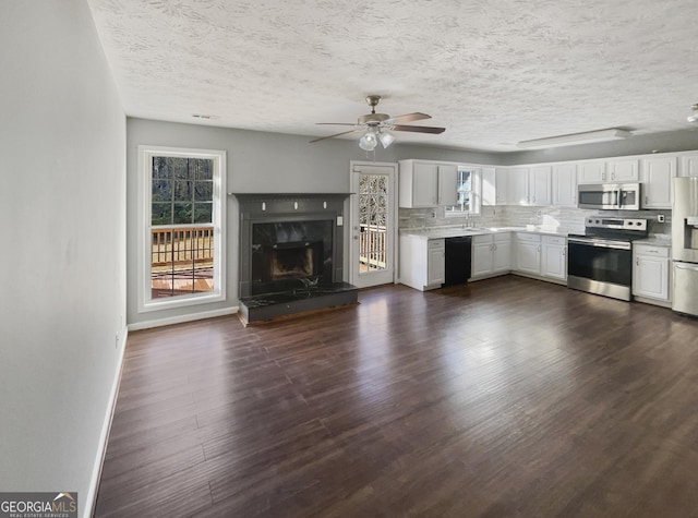 kitchen with stainless steel appliances, tasteful backsplash, plenty of natural light, and white cabinets