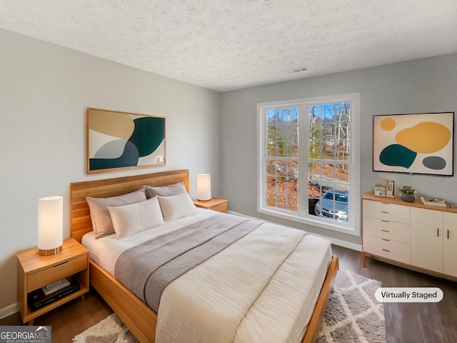 bedroom with hardwood / wood-style flooring and a textured ceiling