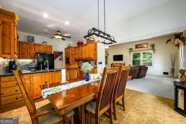 dining room with light carpet, sink, and ceiling fan