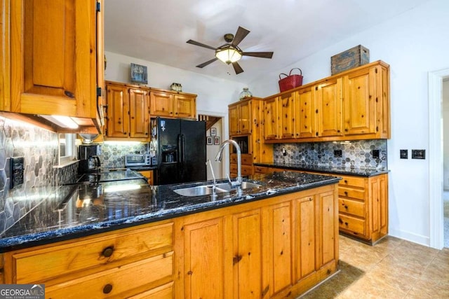 kitchen featuring sink, tasteful backsplash, black appliances, kitchen peninsula, and dark stone counters