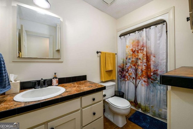 bathroom featuring vanity, tile patterned floors, toilet, and a textured ceiling