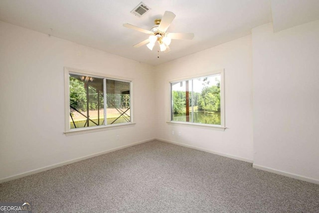 carpeted spare room with ceiling fan