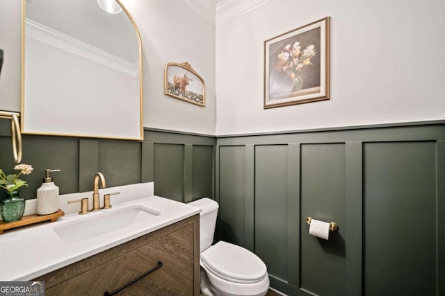 bathroom with ornamental molding, vanity, and toilet