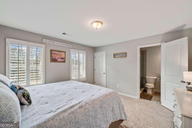 carpeted bedroom featuring ensuite bath