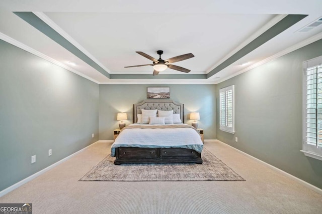 carpeted bedroom with crown molding, a raised ceiling, and ceiling fan