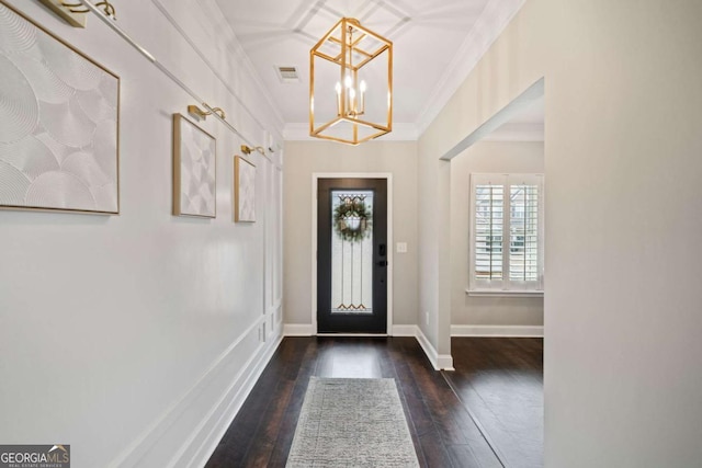 foyer with crown molding, dark hardwood / wood-style flooring, and a notable chandelier