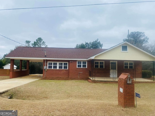 ranch-style house featuring a front lawn and a carport