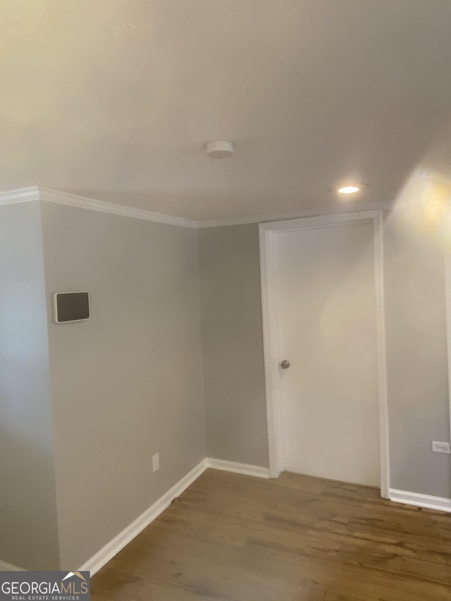 empty room with ornamental molding and dark hardwood / wood-style floors