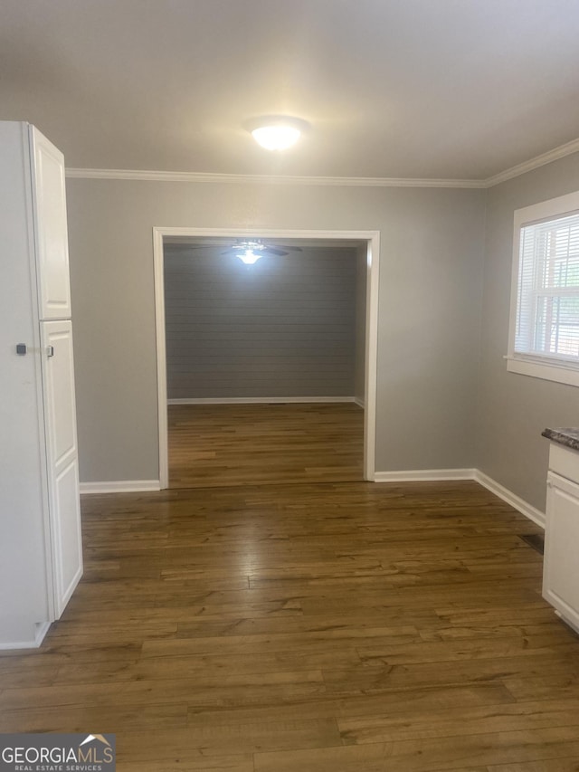 empty room featuring crown molding and dark hardwood / wood-style floors