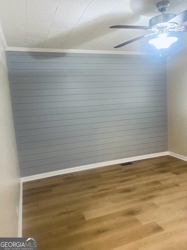 unfurnished room featuring crown molding, hardwood / wood-style floors, and ceiling fan