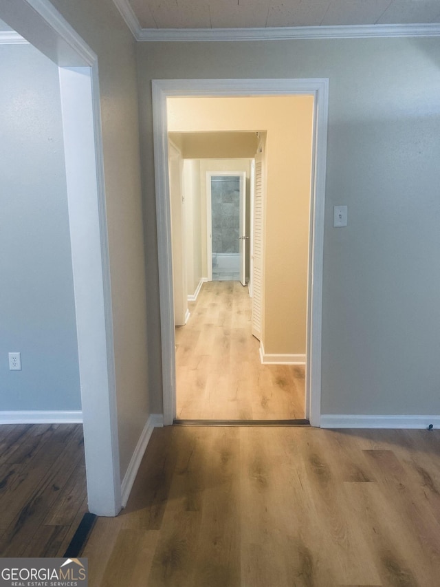 hall with wood-type flooring and ornamental molding