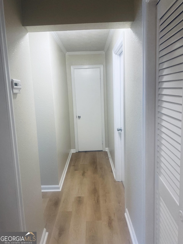 hallway featuring ornamental molding and light wood-type flooring