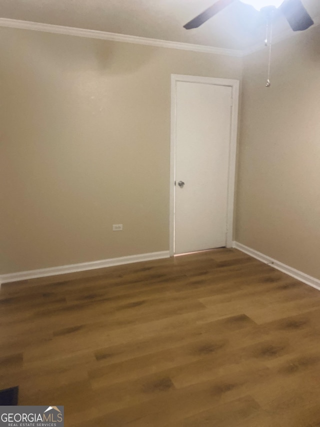 empty room with wood-type flooring, ornamental molding, and ceiling fan