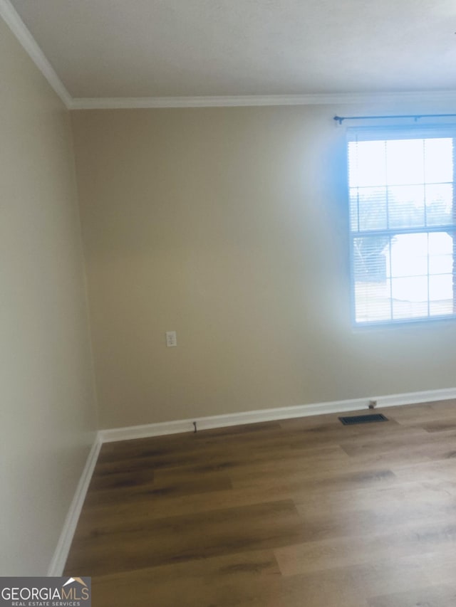 spare room with crown molding and hardwood / wood-style floors