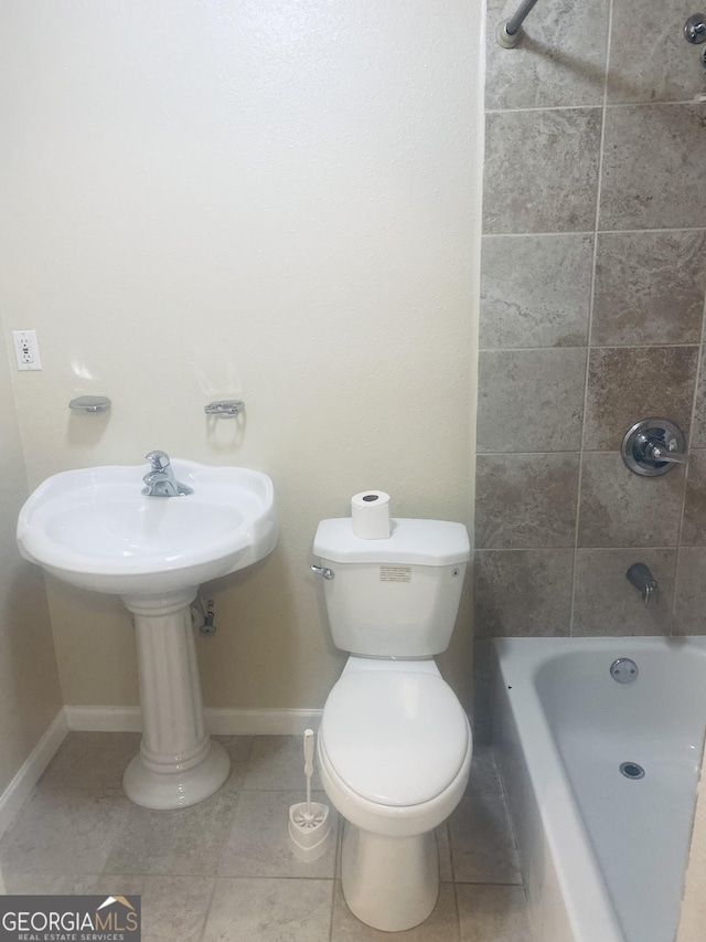 bathroom featuring toilet, tiled shower / bath combo, and tile patterned flooring