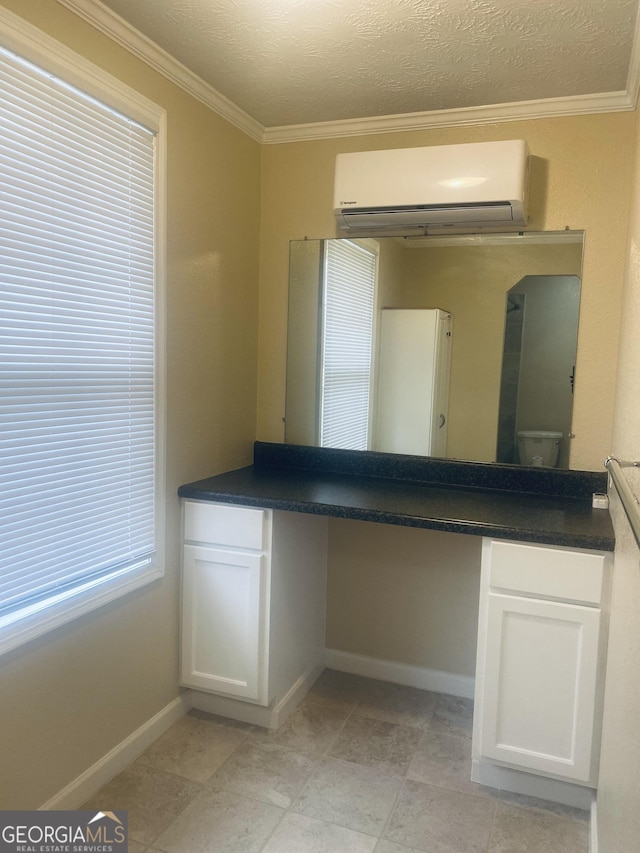 bathroom with crown molding, a wall unit AC, and a textured ceiling