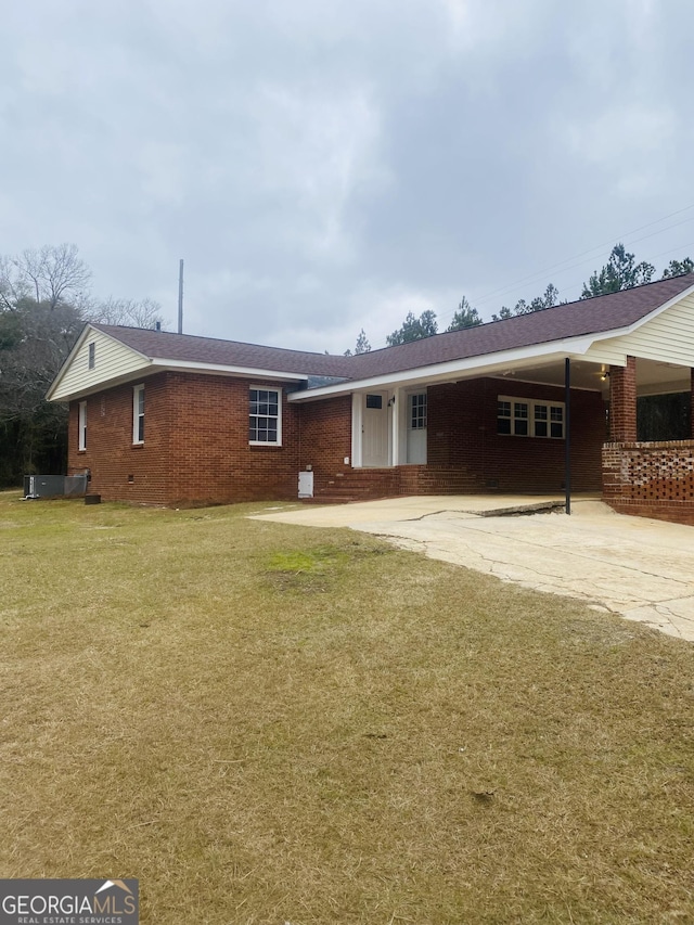 ranch-style home with a carport and a front lawn