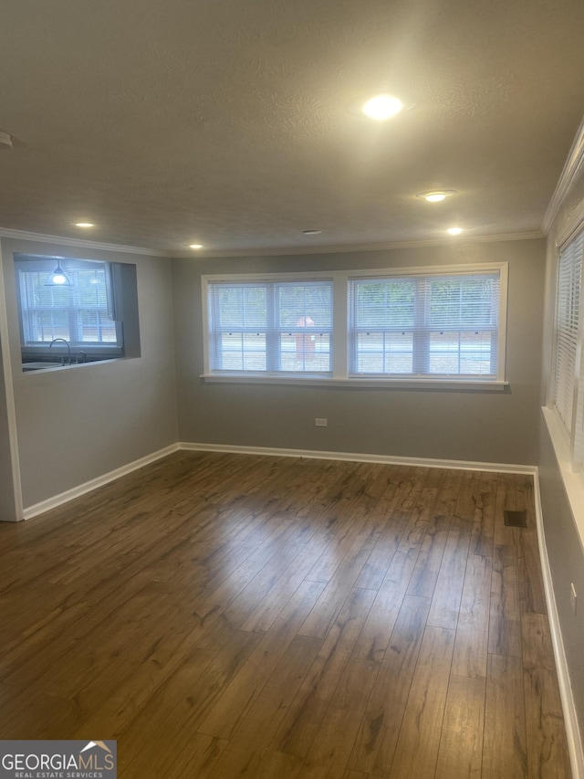 unfurnished room with ornamental molding, dark hardwood / wood-style flooring, and a textured ceiling