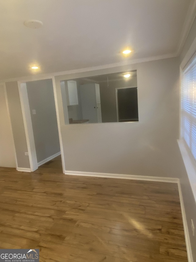 spare room featuring hardwood / wood-style flooring and ornamental molding