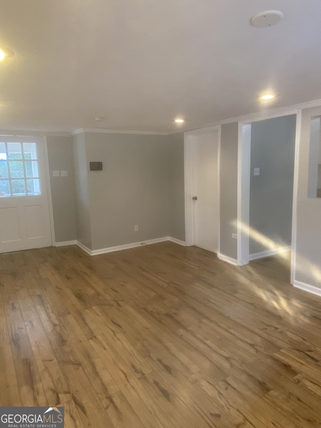 spare room with crown molding and wood-type flooring