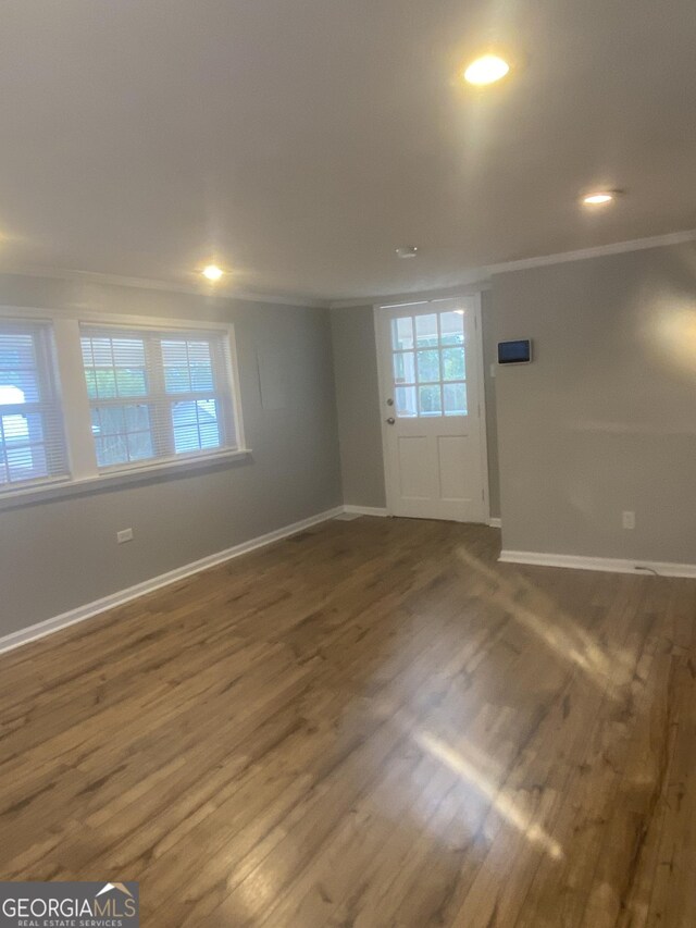 spare room with crown molding and dark hardwood / wood-style floors