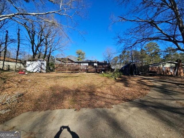 view of yard with a wooden deck and a shed