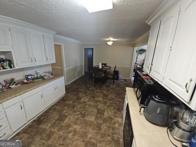 kitchen with decorative backsplash, ornamental molding, a textured ceiling, and white cabinets