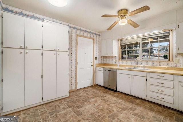 kitchen featuring ceiling fan, stainless steel dishwasher, sink, and white cabinets