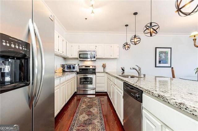 kitchen with sink, white cabinetry, ornamental molding, pendant lighting, and stainless steel appliances