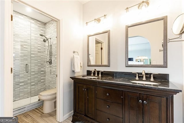 bathroom with vanity, toilet, a shower with shower door, and wood-type flooring