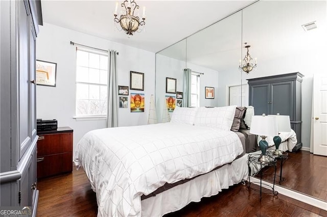 bedroom featuring dark hardwood / wood-style floors and a chandelier