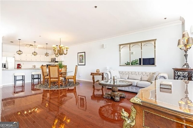 living room with hardwood / wood-style flooring, ornamental molding, and a chandelier