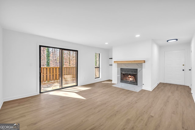 unfurnished living room featuring light hardwood / wood-style floors and a premium fireplace