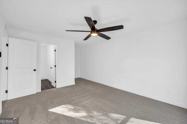 unfurnished room featuring ceiling fan and dark colored carpet