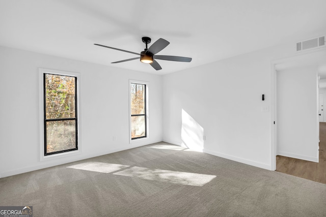 carpeted spare room with ceiling fan