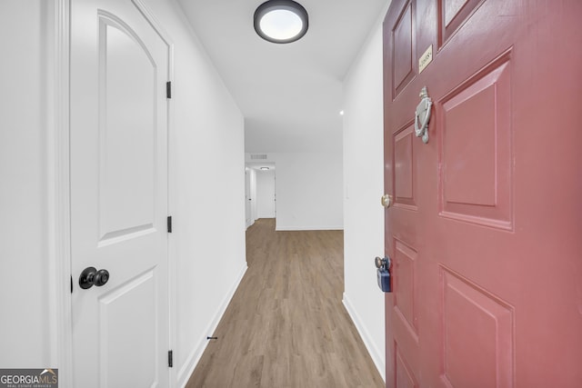 corridor with light hardwood / wood-style flooring