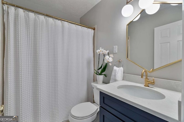 bathroom featuring vanity, a textured ceiling, and toilet