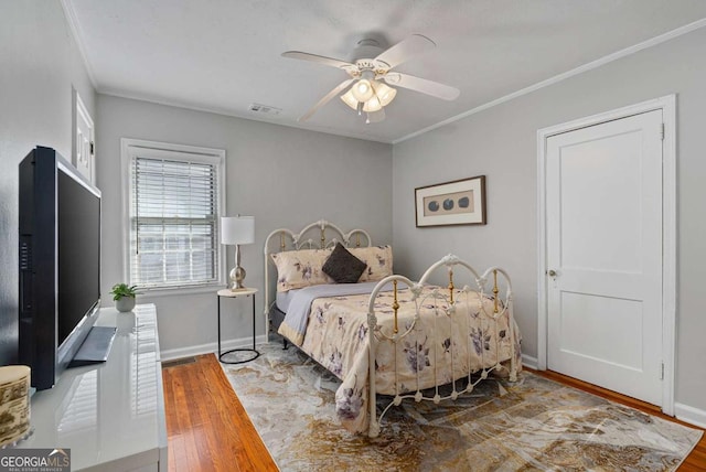 bedroom featuring wood-type flooring, ornamental molding, and ceiling fan