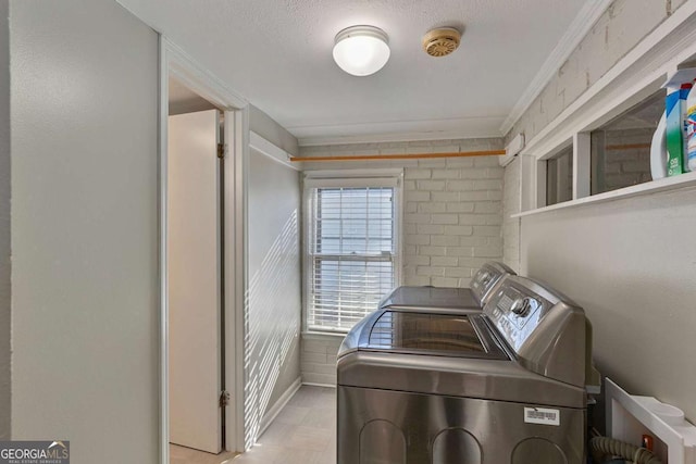 laundry room with ornamental molding, a textured ceiling, and independent washer and dryer